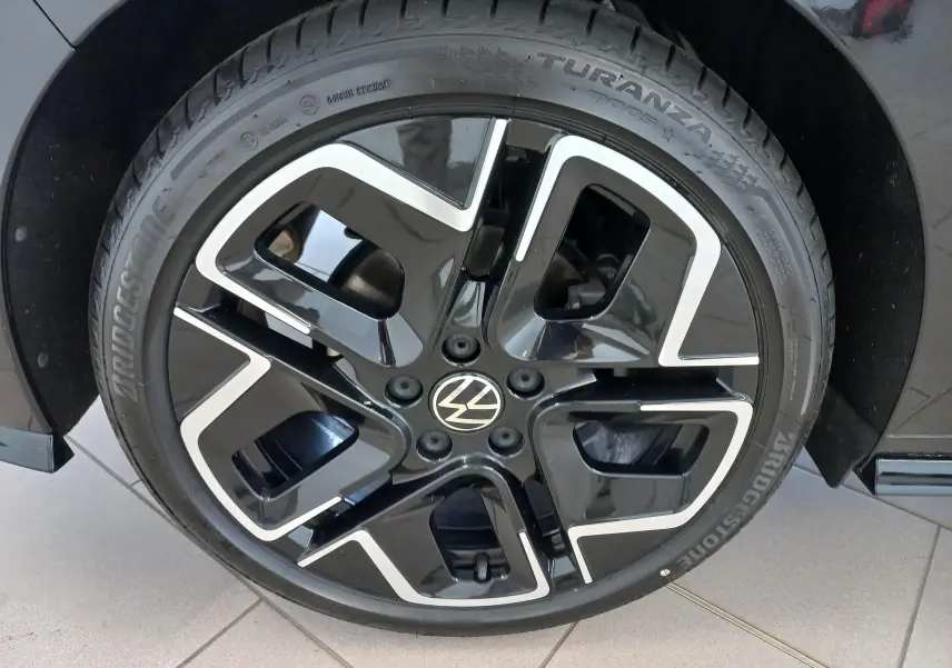 Gros plan sur la jante noire et argentée d'une Volkswagen Golf 1.5 eTSI 150 DSG7 R-Line Edition noir ébène.