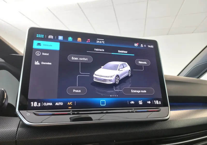 Écran tactile intérieur affichant la vue 360° d'une Volkswagen Golf noire, avec commandes climatisation visibles.