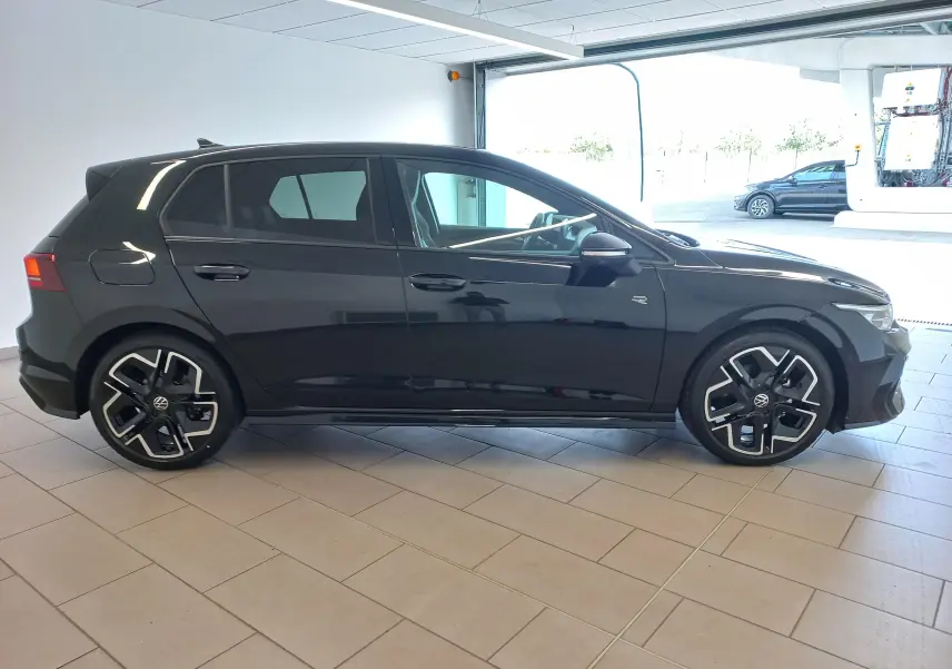 Volkswagen Golf 1.5 eTSI R-Line noir Ébène vue de profil côté gauche en intérieur, jantes alliage distinctives.