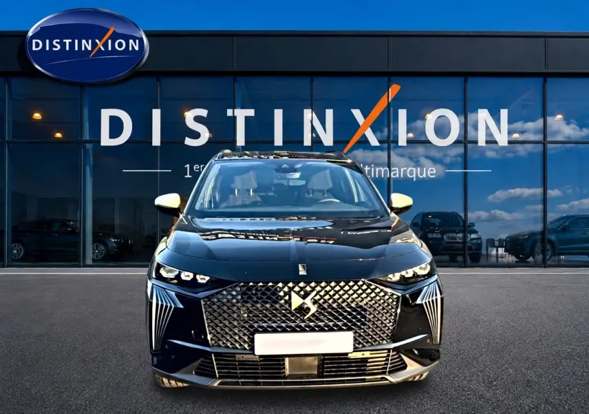 Vue de face du DS7 noir 2026 avec sa calandre distinctive et ses phares LED, devant une vitrine Distinxion.