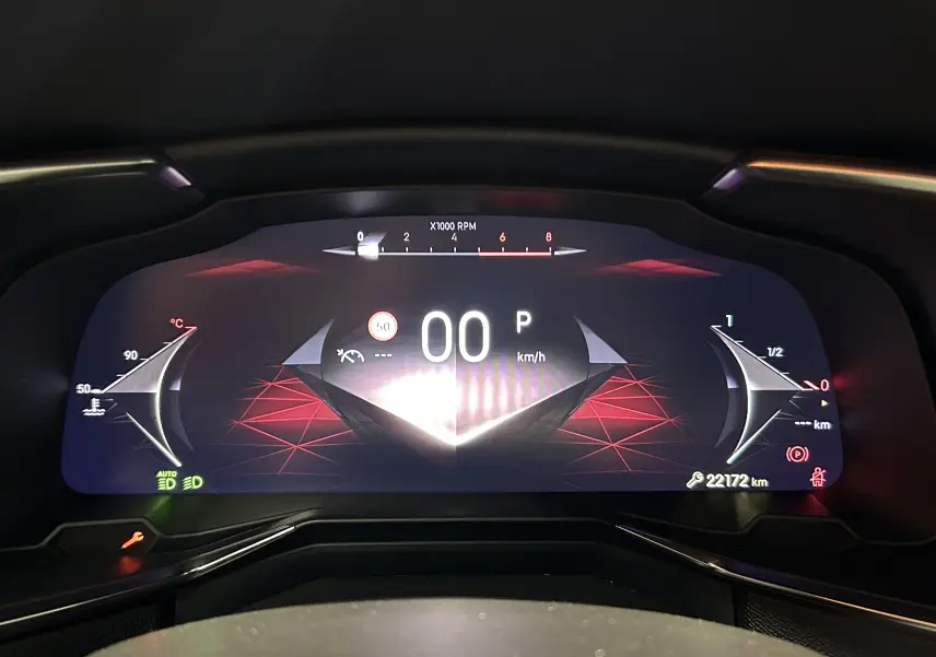 Tableau de bord numérique du DS7 2024 affichant la vitesse à 0 km/h avec un design graphique rouge et noir.