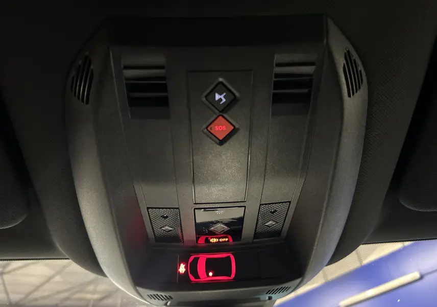 Vue en gros plan du plafonnier intérieur du DS7 2024 avec boutons SOS et signal sonore, éclairage rouge activé.