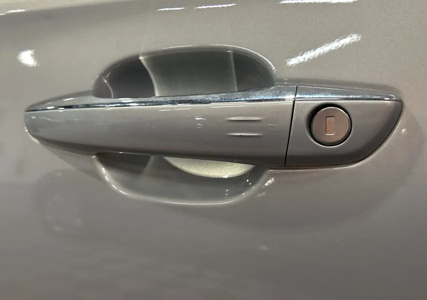 Poignée de porte côté gauche en gros plan sur DS7 2024 couleur Cristal Pearl avec serrure intégrée.
