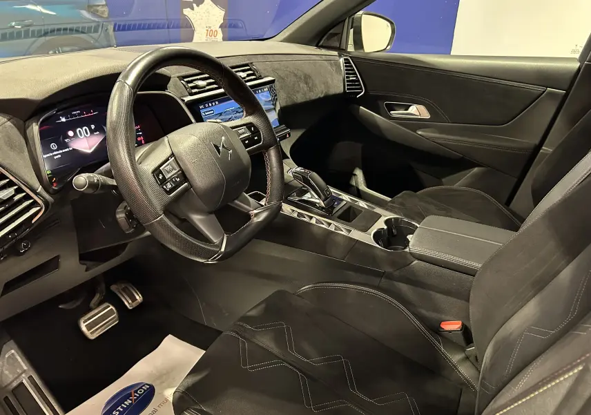 Vue intérieure côté conducteur du DS7 2024, mettant en valeur le volant cuir perforé et la console centrale moderne.