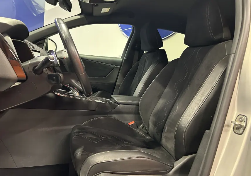 Vue intérieure côté conducteur du DS7 2024 avec sièges en cuir noir et détails de la console centrale visibles.