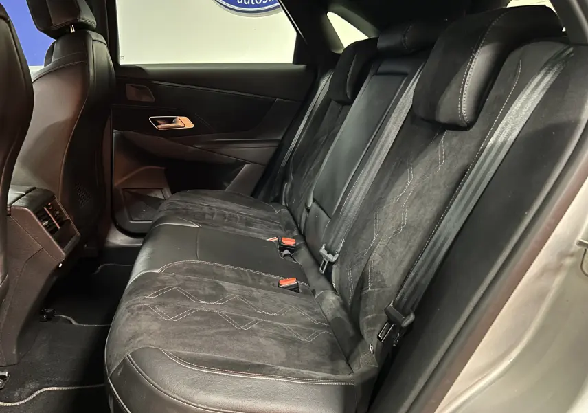 Vue latérale droite de l'intérieur arrière du DS7 2024, sièges en cuir et alcantara noirs avec surpiqûres contrastées.