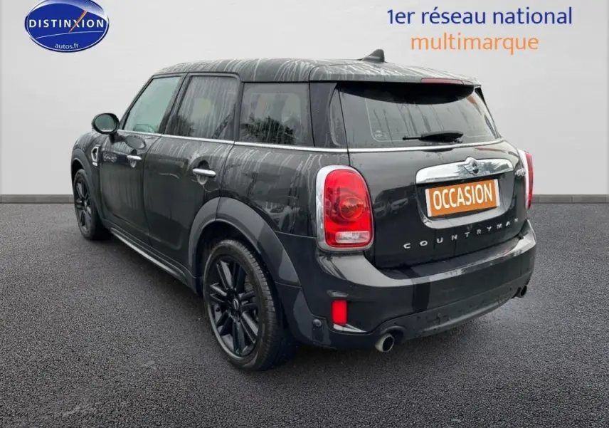 Vue 3/4 arrière droite d'une MINI Countryman noire avec jantes alliage noires et toit ouvrant panoramique visible.