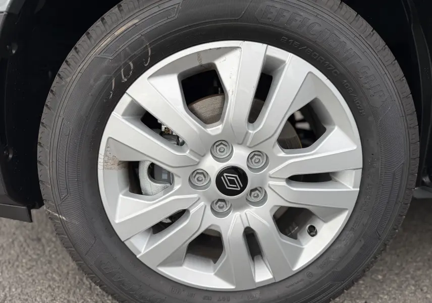 Gros plan sur la roue avant droite du Renault Trafic Combi gris urbain, avec jante alliage et logo Renault central.