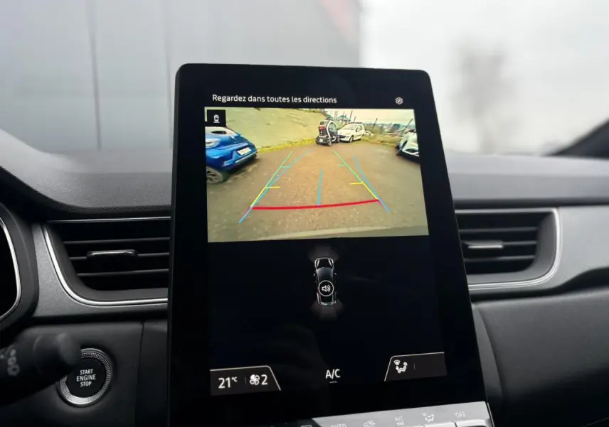 Vue intérieure du tableau de bord du Renault Captur 2025 avec écran tactile affichant la caméra de recul en marche.