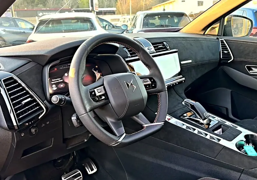 Intérieur de DS7 1.5 BlueHDi 130 noir, vue côté conducteur sur volant cuir et console centrale moderne.