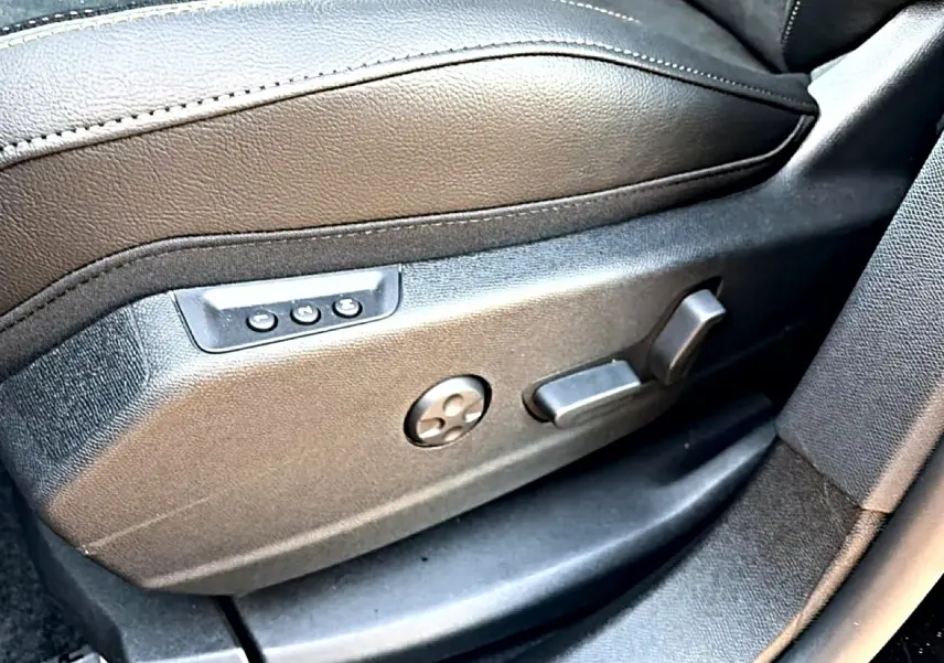 Gros plan sur les commandes électriques du siège conducteur en cuir noir du DS7 1.5 BlueHDi 130 Performance Line 2026.