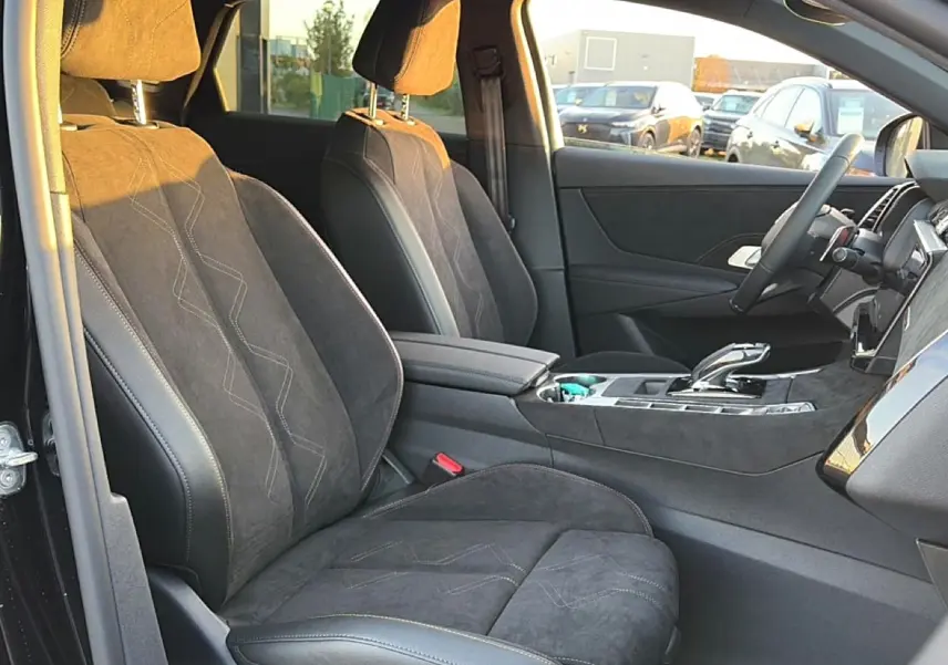 Vue intérieure côté conducteur du DS7 1.5 BlueHDi noir, sièges en alcantara avec surpiqûres et console centrale moderne.