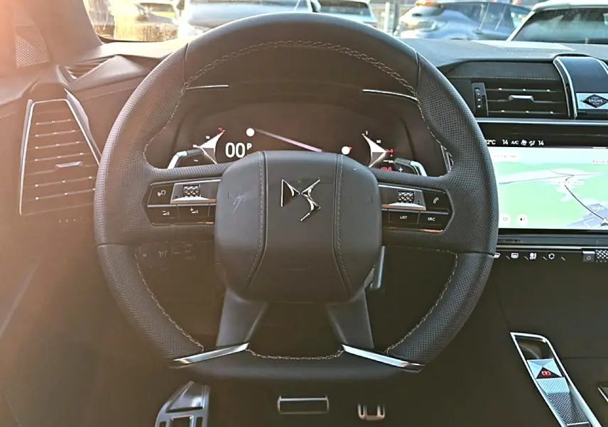 Vue rapprochée du volant cuir noir du DS7 1.5 BlueHDi 130, avec commandes intégrées et tableau de bord numérique.