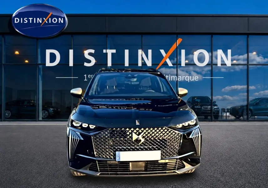 Vue frontale d'un DS7 noir 2026 avec calandre diamantée et phares LED distinctifs, devant une vitrine Distinxion.
