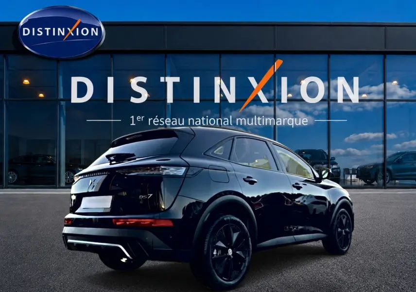 Vue 3/4 arrière droite du DS7 noir brillant avec jantes noires, devant une vitrine Distinxion réfléchissante.