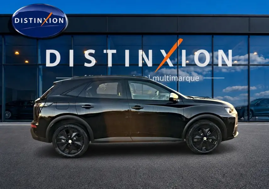 Vue de profil côté gauche d'un DS7 noir 2026 avec jantes noires, garé devant une vitrine Distinxion.