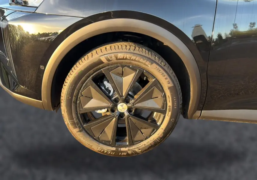 Gros plan sur la roue avant gauche noire du DS7 1.5 BlueHDi 130 Performance Line avec jante alu noire géométrique.