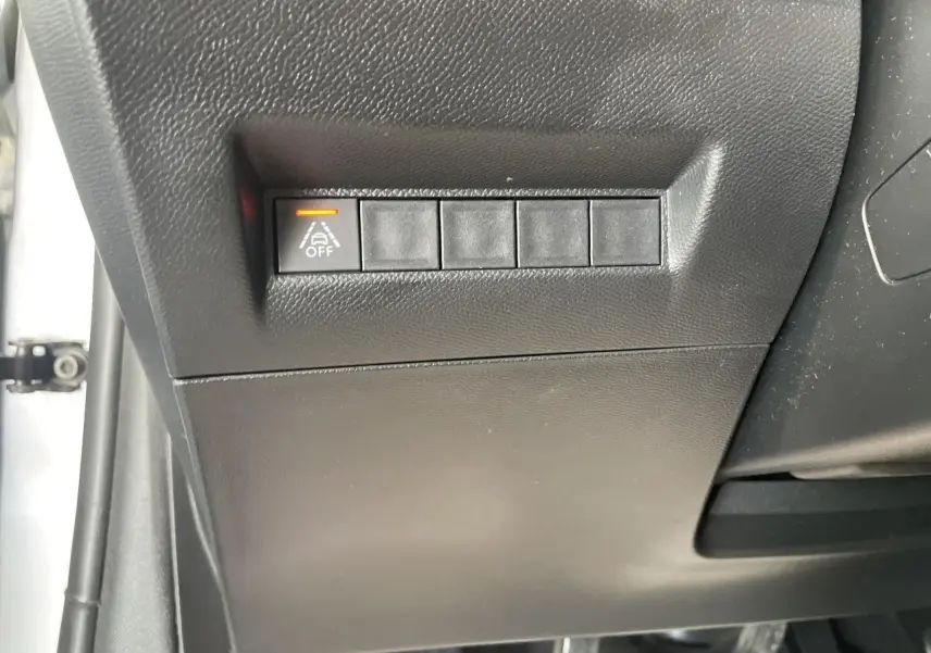 Bouton d'activation du système d'alerte de franchissement de ligne désactivé sur tableau de bord Peugeot 208 gris clair.