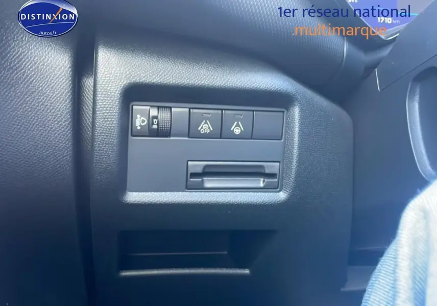 Gros plan sur les commandes de réglage des phares et aides à la conduite dans un Citroën C5 Aircross gris platinium 2025.