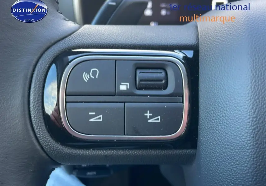 Gros plan sur les commandes vocales et volume au volant cuir noir du Citroën C5 Aircross gris platinium 2025.