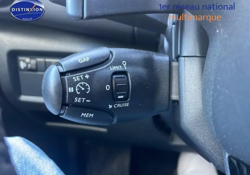 Gros plan sur la commande de régulateur de vitesse au volant du Citroën C5 Aircross gris platinium 2025.