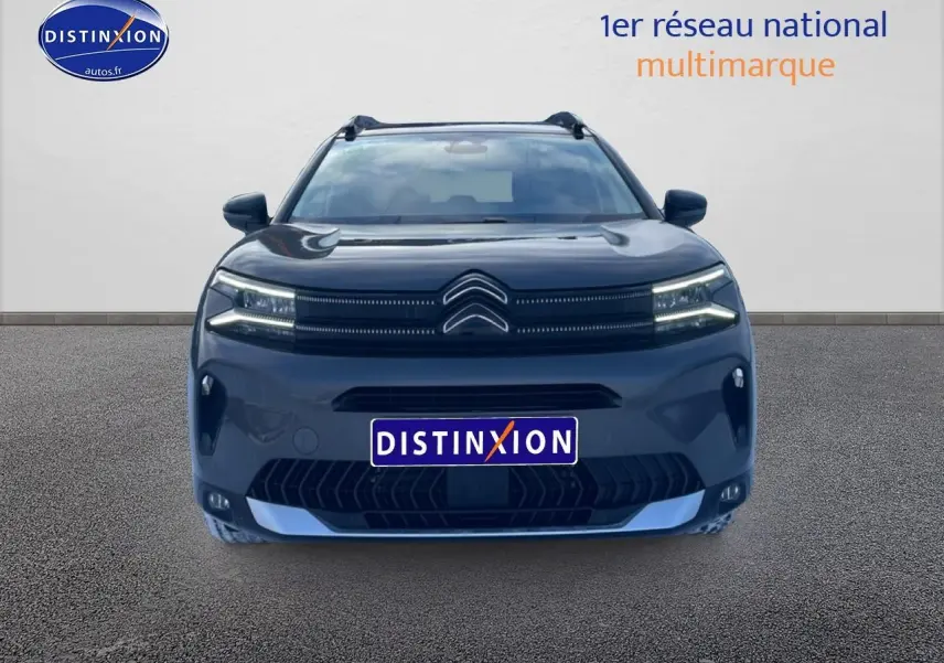 Vue de face du Citroën C5 Aircross gris platinium avec calandre distinctive et phares LED allumés.