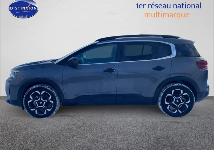 Profil côté gauche d’un Citroën C5 Aircross gris platinium 2025 avec barres de toit et jantes alu distinctives.