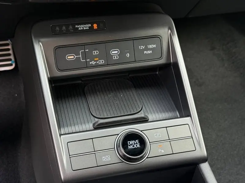 Gros plan sur la console centrale du Hyundai KONA 2025, avec commandes Drive Mode et chargeur sans fil.
