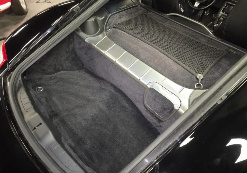 Vue plongeante du coffre avant noir de la Porsche Cayman 2.7i 2008 avec filet de rangement et intérieur soigné.