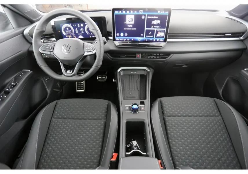 Vue intérieure avant du Volkswagen T-Roc 2026, tableau de bord numérique et sièges sport tissu R-Line noirs.
