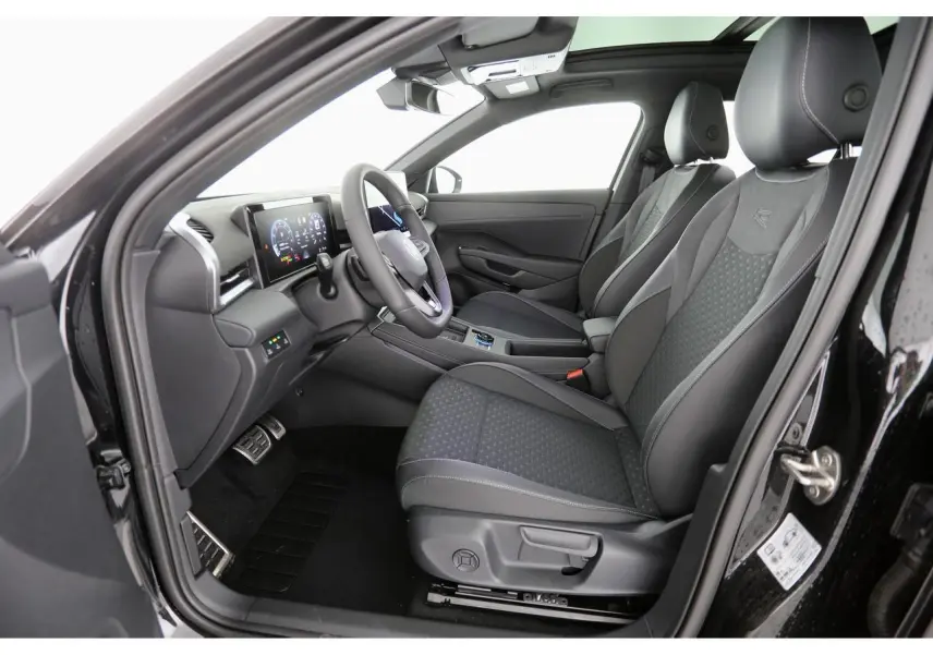Vue intérieure côté conducteur du Volkswagen T-Roc 2026 avec sièges sport tissu R-Line noirs et tableau de bord digital.