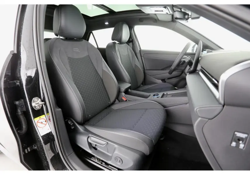 Vue intérieure côté gauche du Volkswagen T-Roc 2026, sièges sport R-Line en tissu noir avec surpiqûres grises.