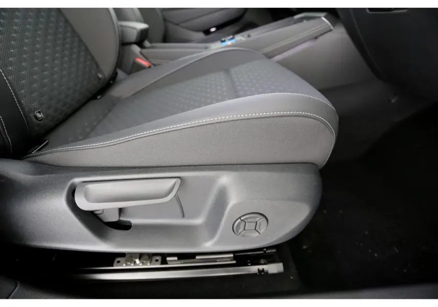 Détail du siège avant gauche en tissu gris avec réglages manuels dans l'habitacle du Volkswagen T-Roc 2026.