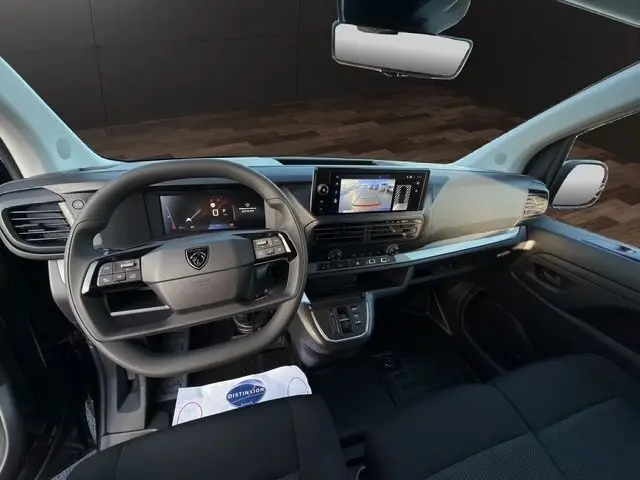 Intérieur du Peugeot Expert Fourgon 2025 vu de face, tableau de bord noir avec écran tactile et volant multifonctions.