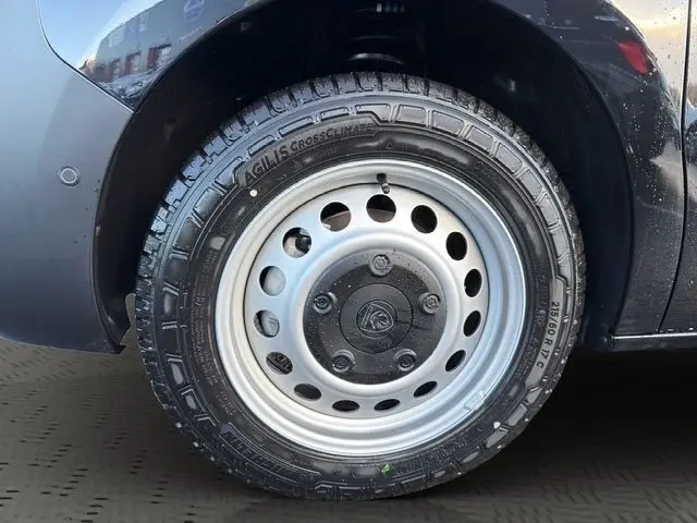 Gros plan sur la roue avant gauche noire du Peugeot Expert Fourgon 2025 avec jante acier et pneu Agilis CrossClimate.