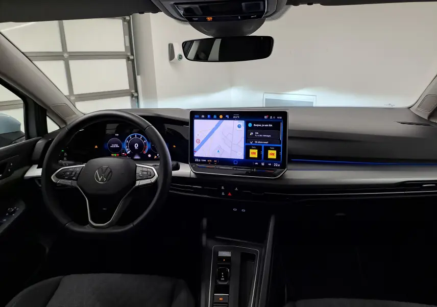Intérieur de la Volkswagen Golf 1.5 eTSI 2025, vue du poste de conduite avec écran tactile central et volant multifonction.