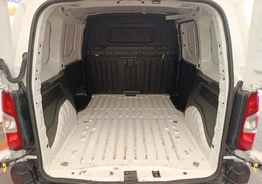 Vue arrière du coffre blanc du Peugeot Partner Taille M 650kg, montrant l’espace de chargement vide avec cloison pleine noire.