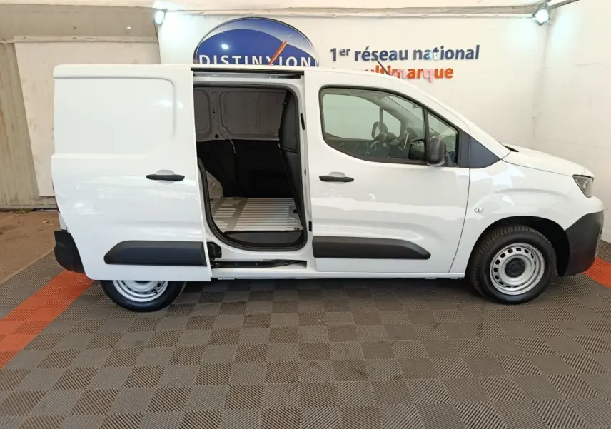 Vue latérale droite d'un Peugeot Partner blanc 2022 avec porte coulissante ouverte montrant l'espace de chargement vide.