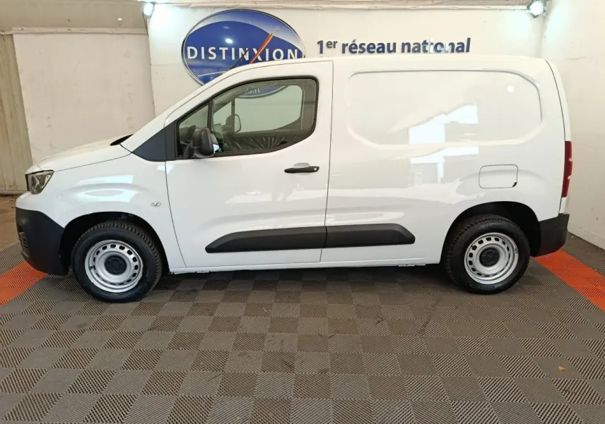 Vue de profil côté gauche d’un utilitaire Peugeot Partner blanc, version Taille M, avec porte latérale pleine et jantes acier.