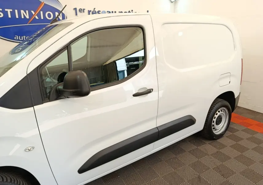 Vue latérale droite d’un Peugeot Partner blanc 2022 avec porte latérale pleine et rétroviseur noir.