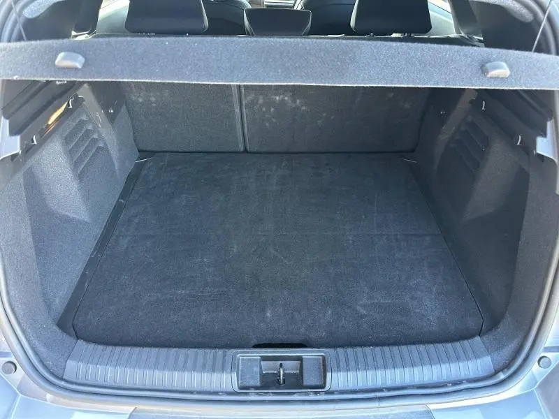 Coffre ouvert vu de l'arrière du Renault SYMBIOZ 1.6 E-Tech rouge, espace de chargement propre et spacieux.