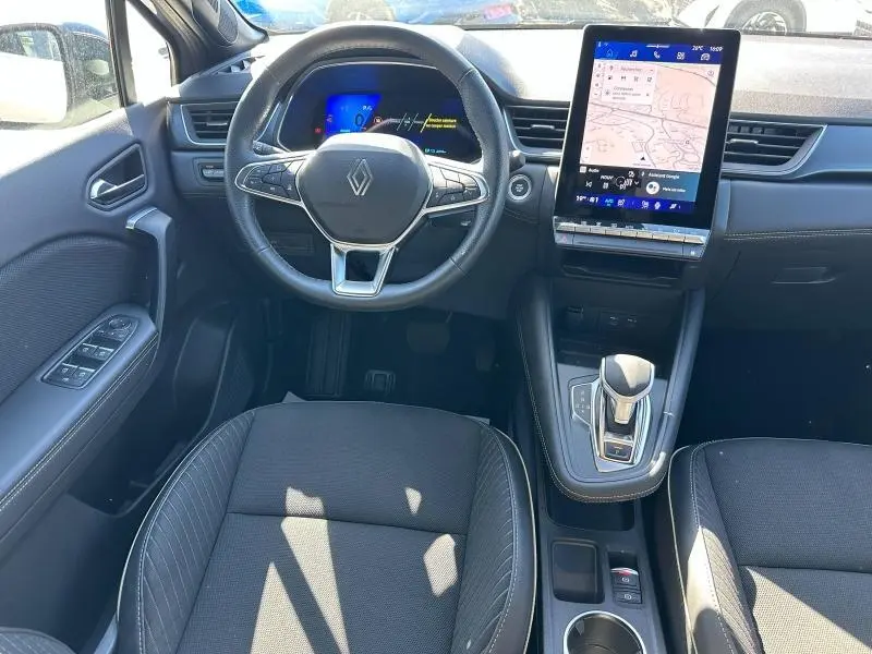 Vue intérieure de face du poste de conduite noir du Renault Symbioz 2025 avec volant multifonction et écran tactile vertical.