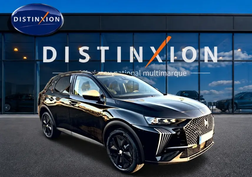 DS7 noir 2026 en 3/4 avant droit, avec calandre distinctive et jantes noires brillantes devant un showroom Distinxion.