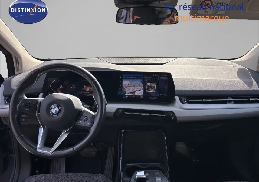 Vue intérieure avant du tableau de bord de la BMW Série 2 Active Tourer 218d gris cuivré avec écran tactile et volant cuir multifonction.