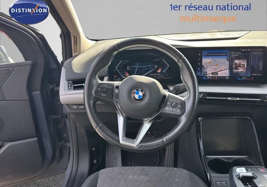 Vue intérieure centrée sur le volant cuir noir et le tableau de bord digital de la BMW Série 2 Active Tourer 218d 2023.
