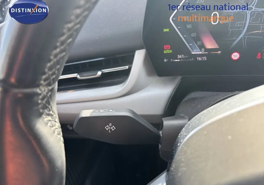Gros plan sur le levier de clignotant à gauche du volant d’une BMW Série 2 Active Tourer 218d gris métallisé, tableau de bord digital visible.