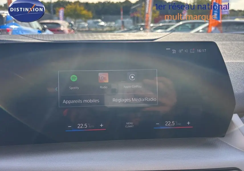 Vue intérieure du tableau de bord de la BMW Série 2 Active Tourer 218d, écran tactile affichant les réglages média et climatisation.