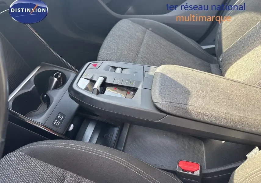 Vue rapprochée de la console centrale et accoudoir du BMW Série 2 Active Tourer 218d, tissu gris et commandes modernes.