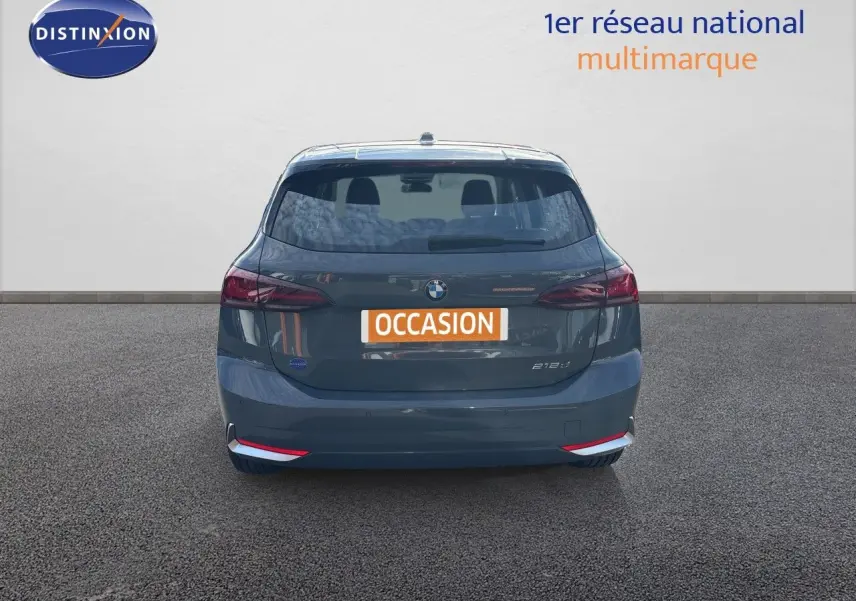 Vue arrière d'une BMW Série 2 Active Tourer 218d gris cuivre métallisé, avec feux arrière LED et plaque "OCCASION".
