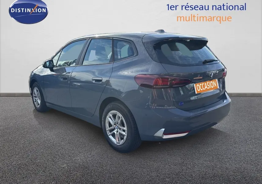BMW Série 2 Active Tourer 218d gris cuivré vue 3/4 arrière droit sur fond neutre avec jantes alliage.